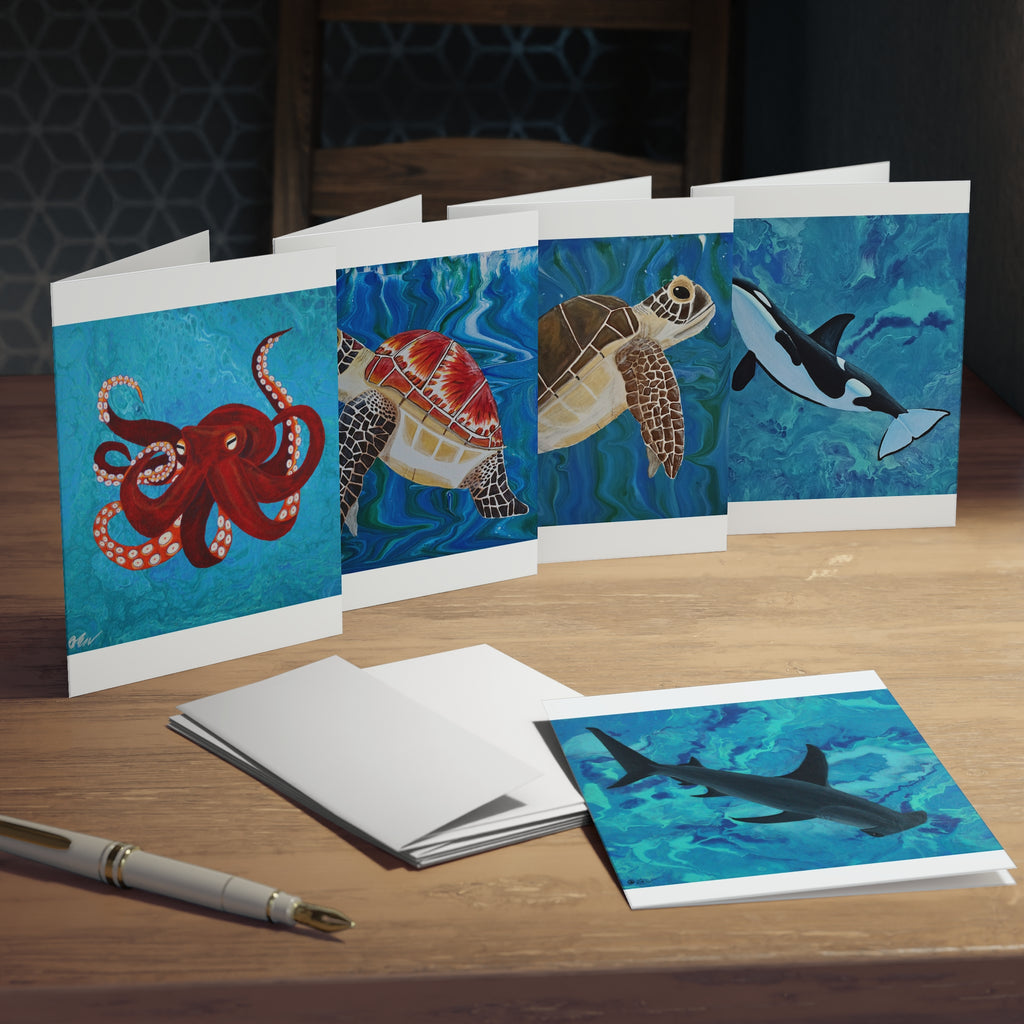 Set of greeting cards with ocean-themed illustrations on a wooden surface.