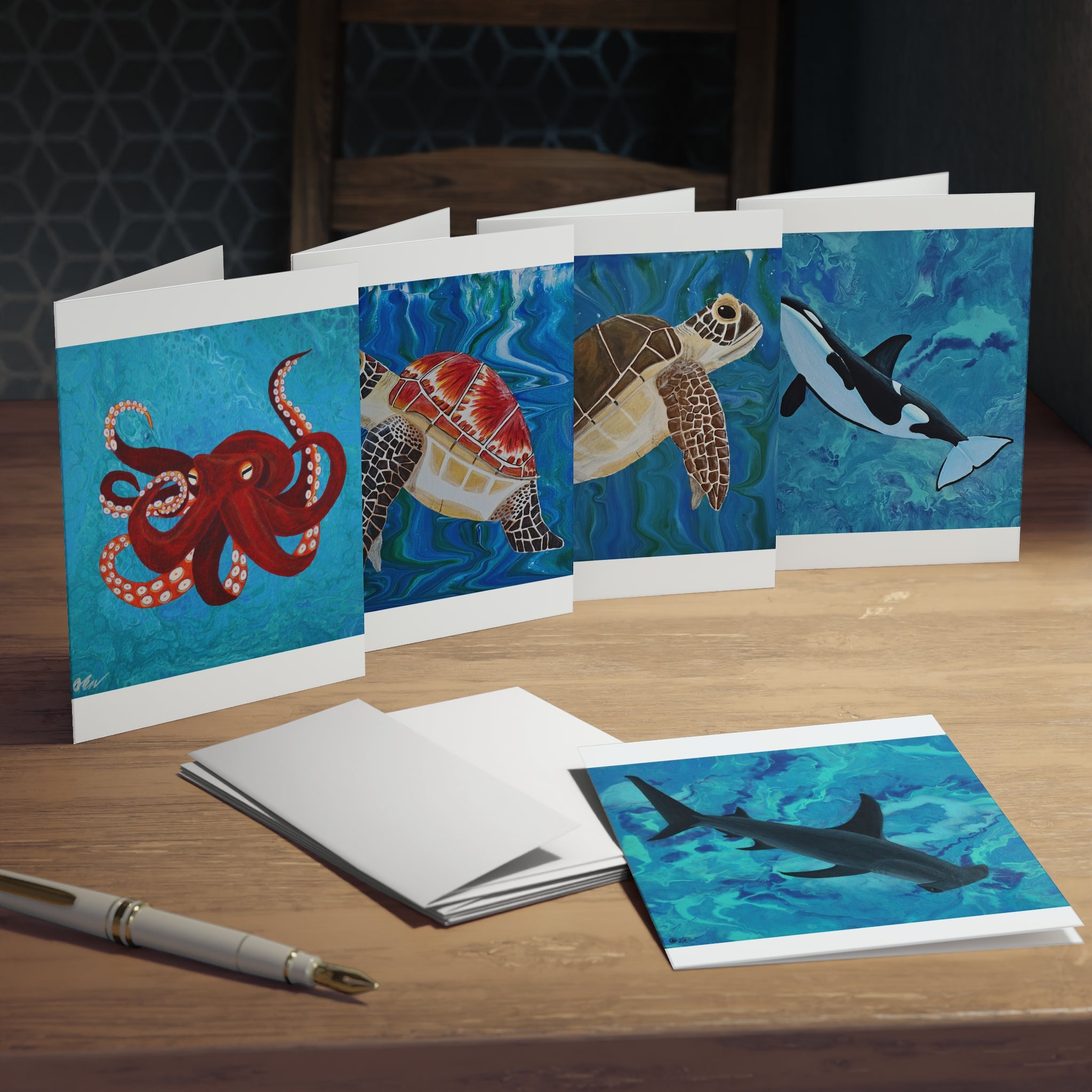 Set of greeting cards with ocean-themed illustrations on a wooden surface.