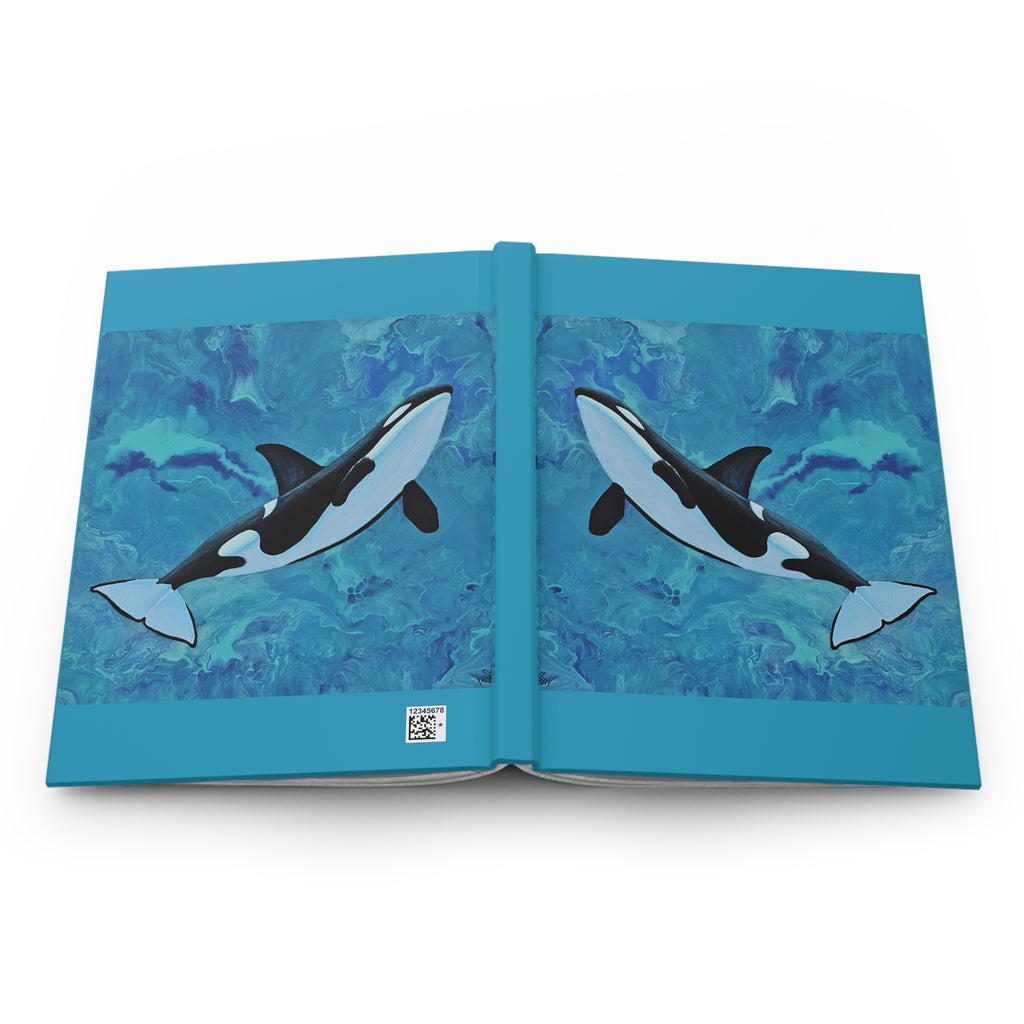 Open book with illustrations of orcas on a blue watercolor background