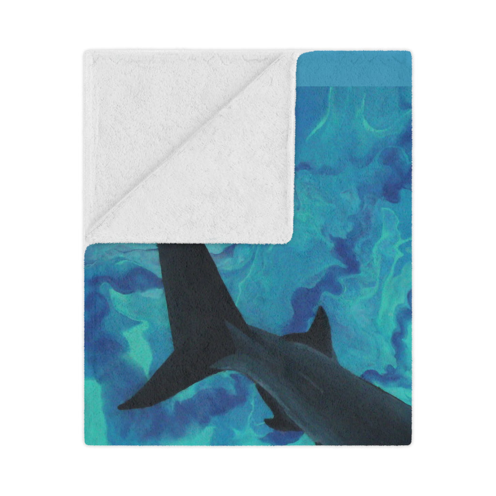 Blanket with shark design on a blue and green patterned background