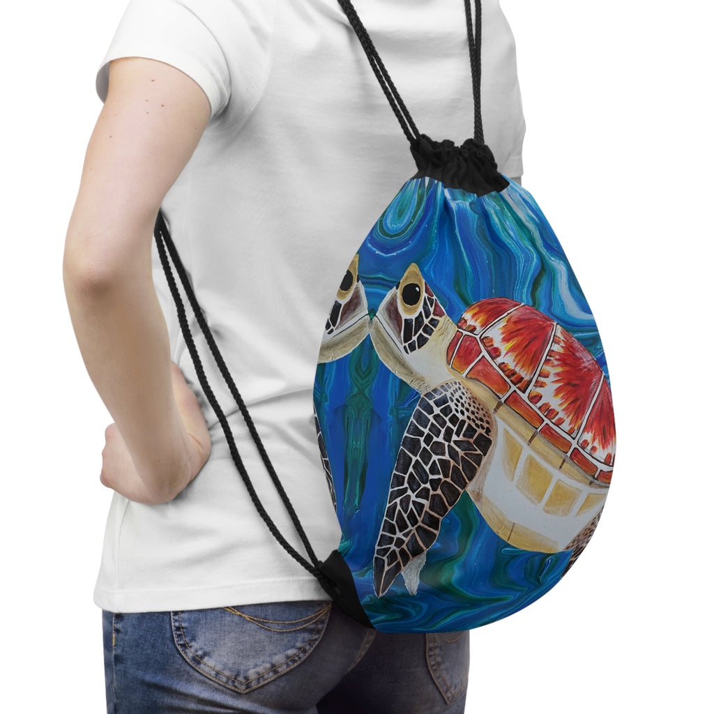 Person holding a drawstring bag with a turtle design on a white background