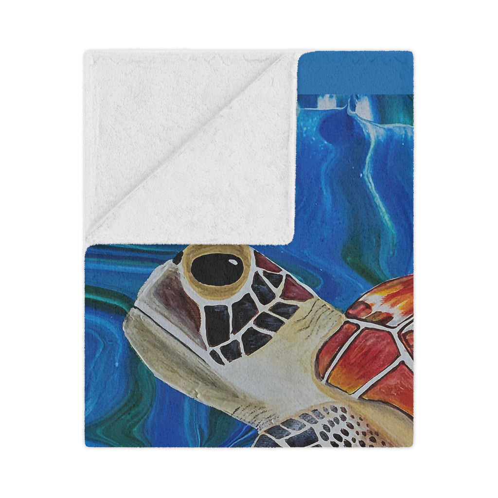 Blanket folded with a turtle design on a blue water background