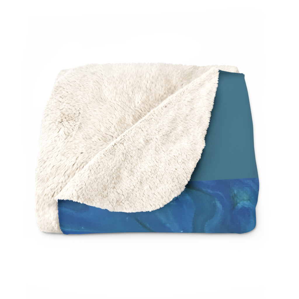 Blue blanket with white sherpa lining on a white background