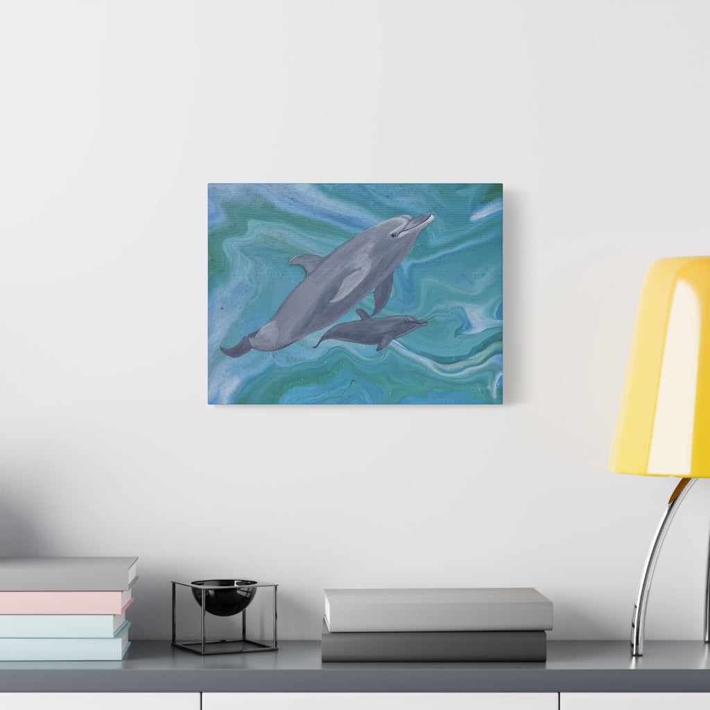 Canvas print of dolphins in water pattern on a wall above a desk with books and a lamp.