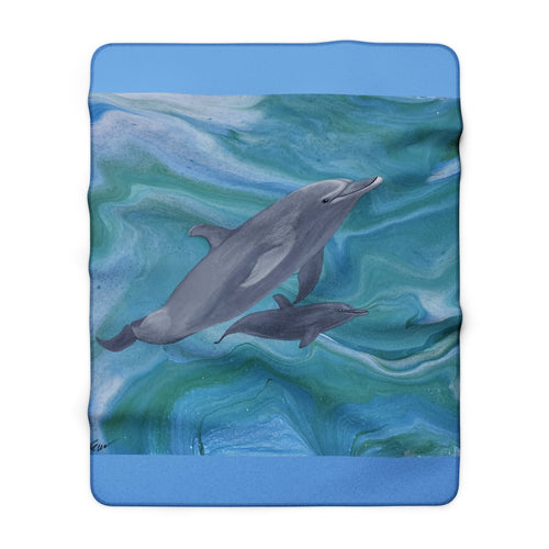Fleece blanket with dolphins design on a blue and green abstract ocean background