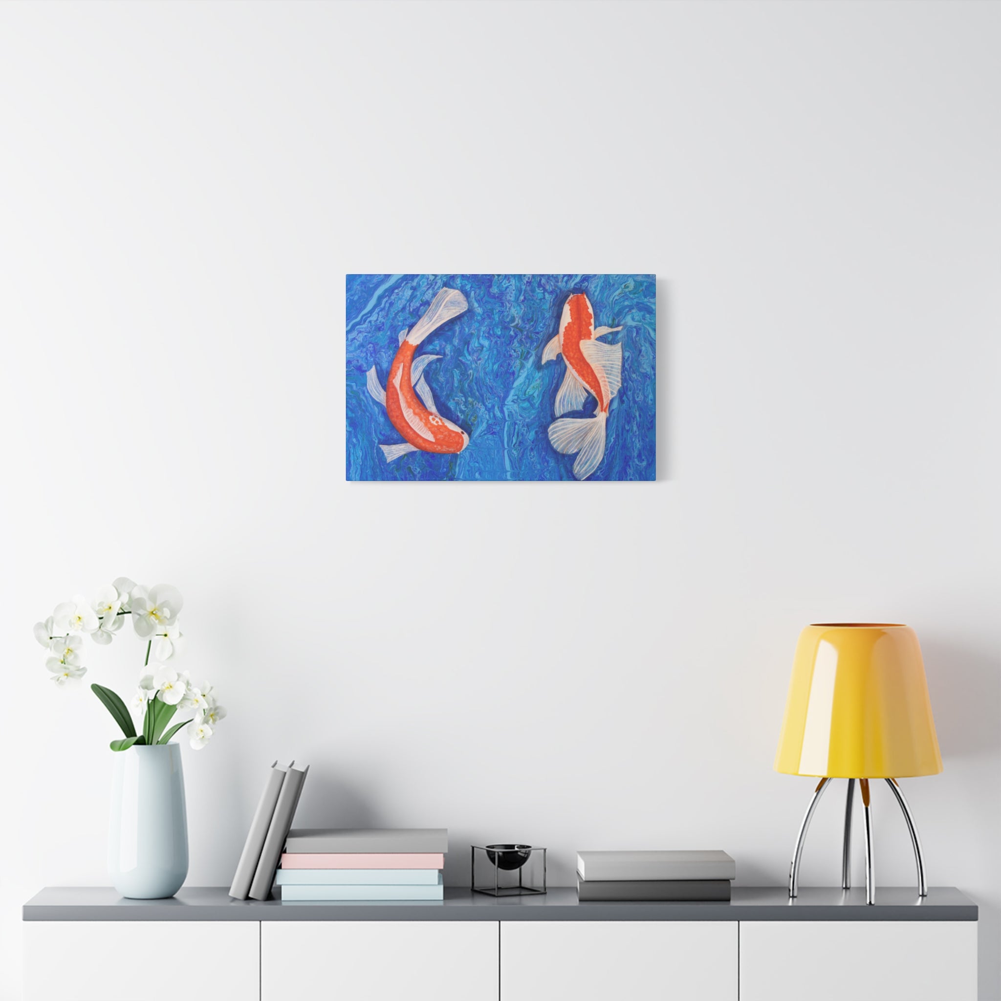 Canvas print of two koi fish on a wall above a shelf with decor items.
