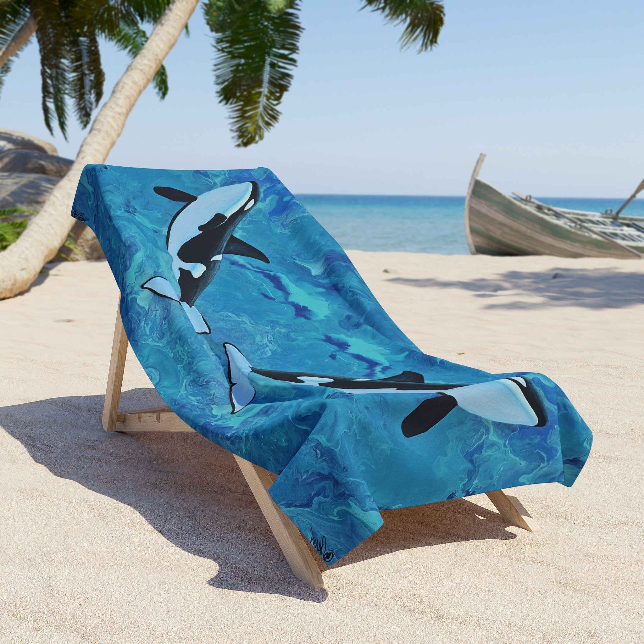 Beach towel/blanket with whale design on a lounge chair at the beach