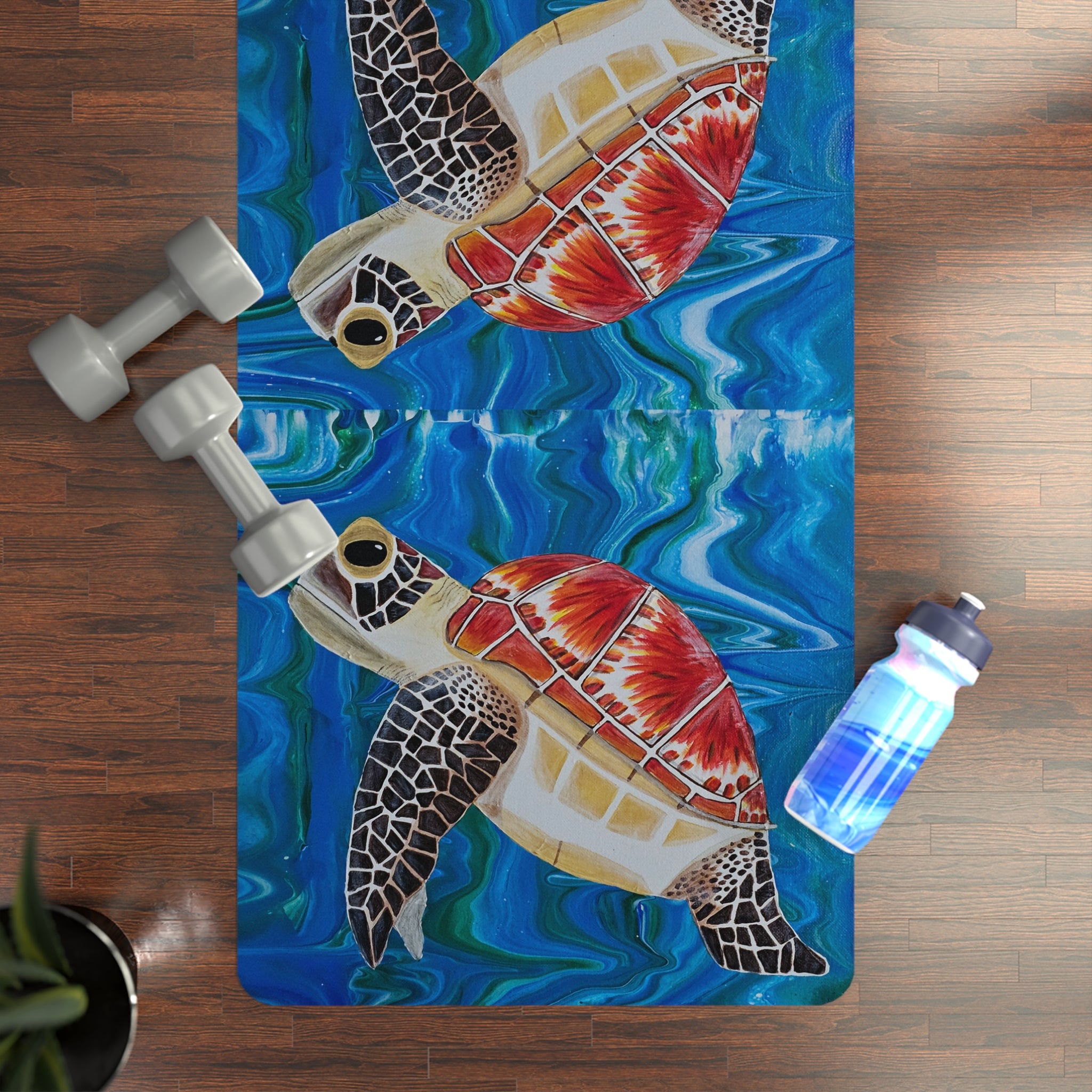 Yoga mat with turtle design on a wooden floor with weights and a water bottle.