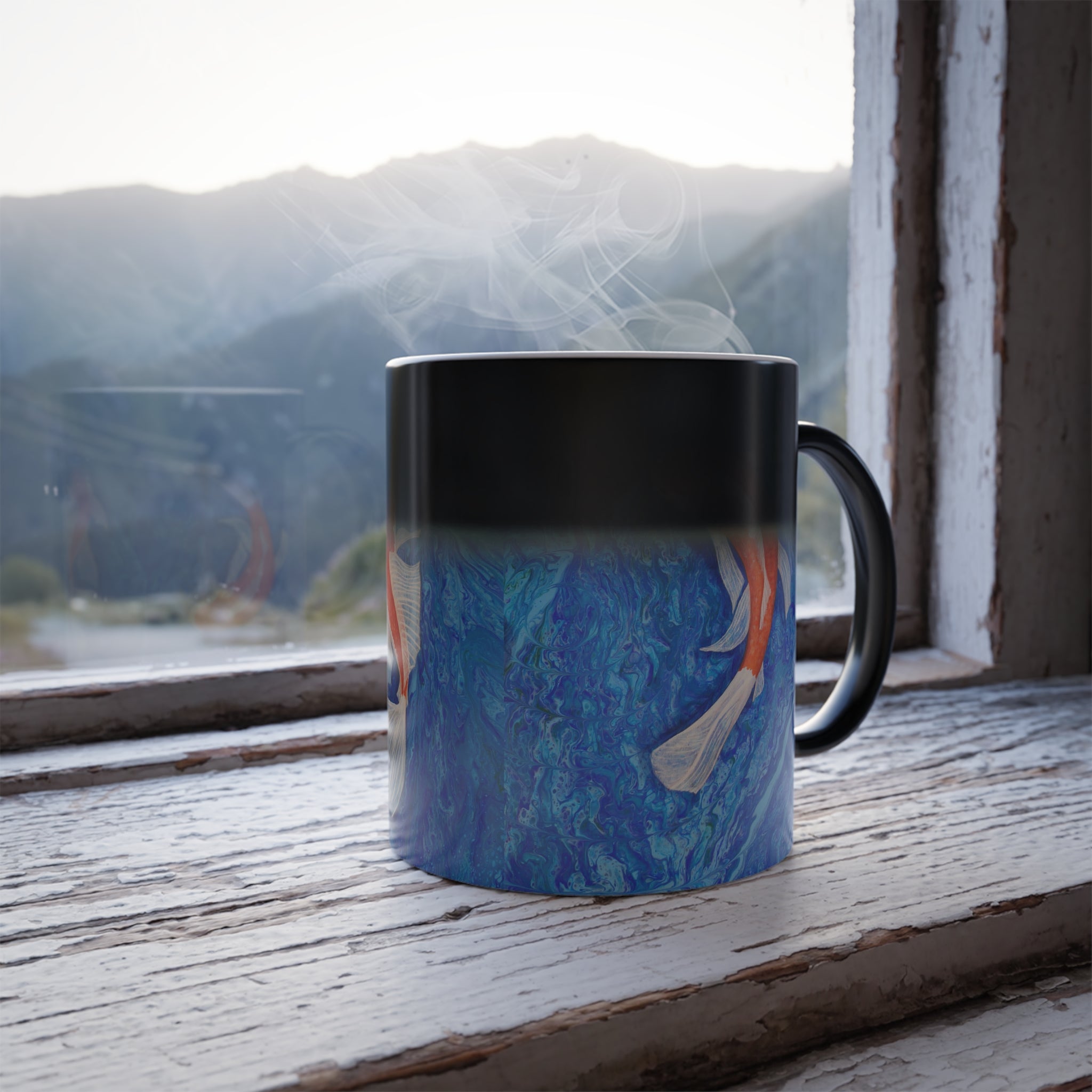 Mug with a blue design on a wooden surface with a mountain view in the background