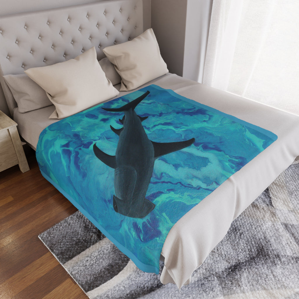 Bed with a shark-themed blanket draped over it in a bedroom setting.