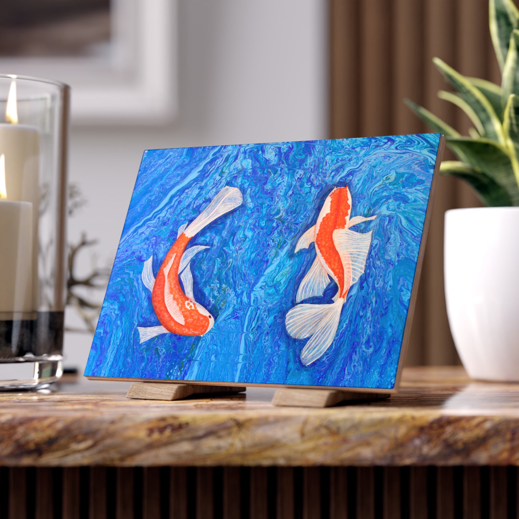 Artistic depiction of two koi fish on a blue background tile, displayed on a wooden stand.
