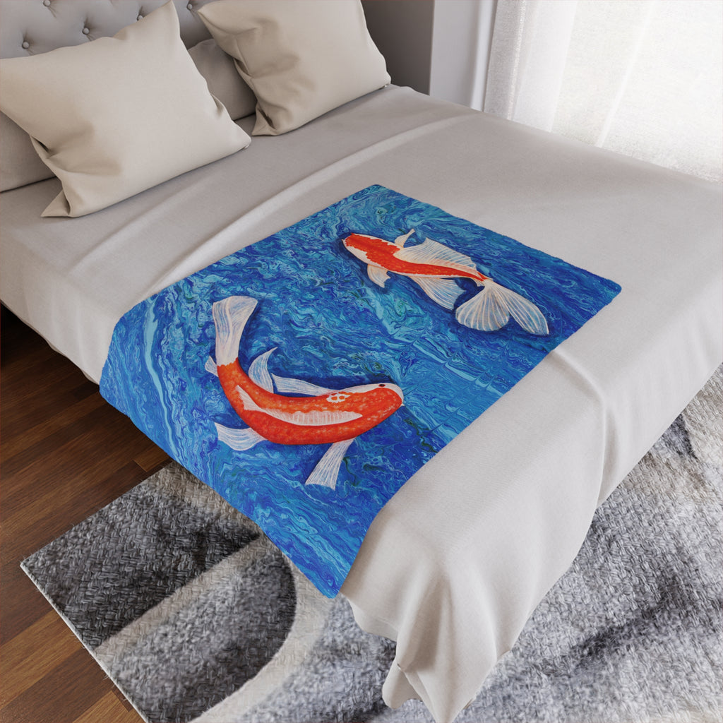 Bed with a decorative throw featuring koi fish design on a blue background