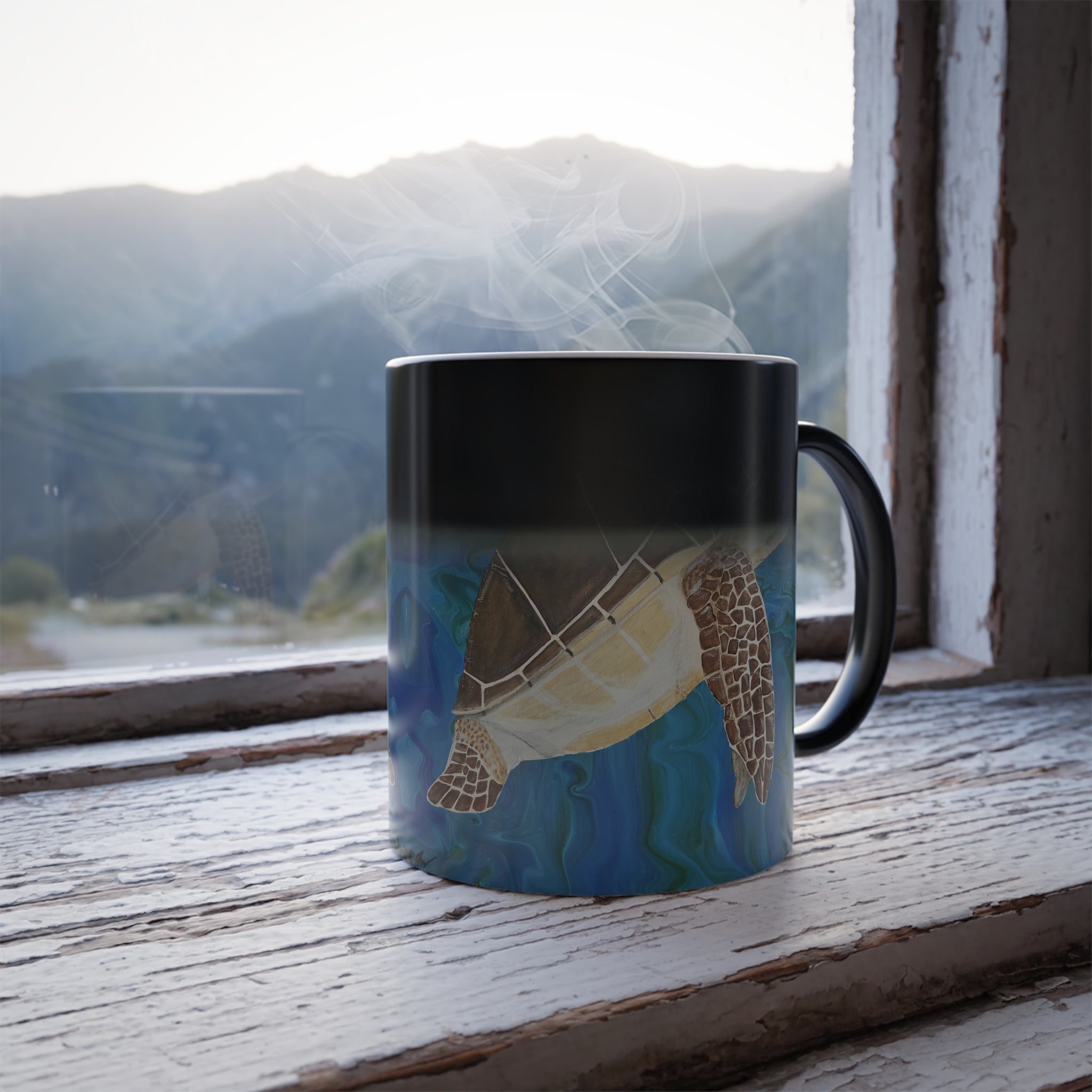 Mug with a turtle design on a windowsill with a mountain view