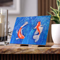 Decorative tile with koi fish on a blue background on a wooden surface.