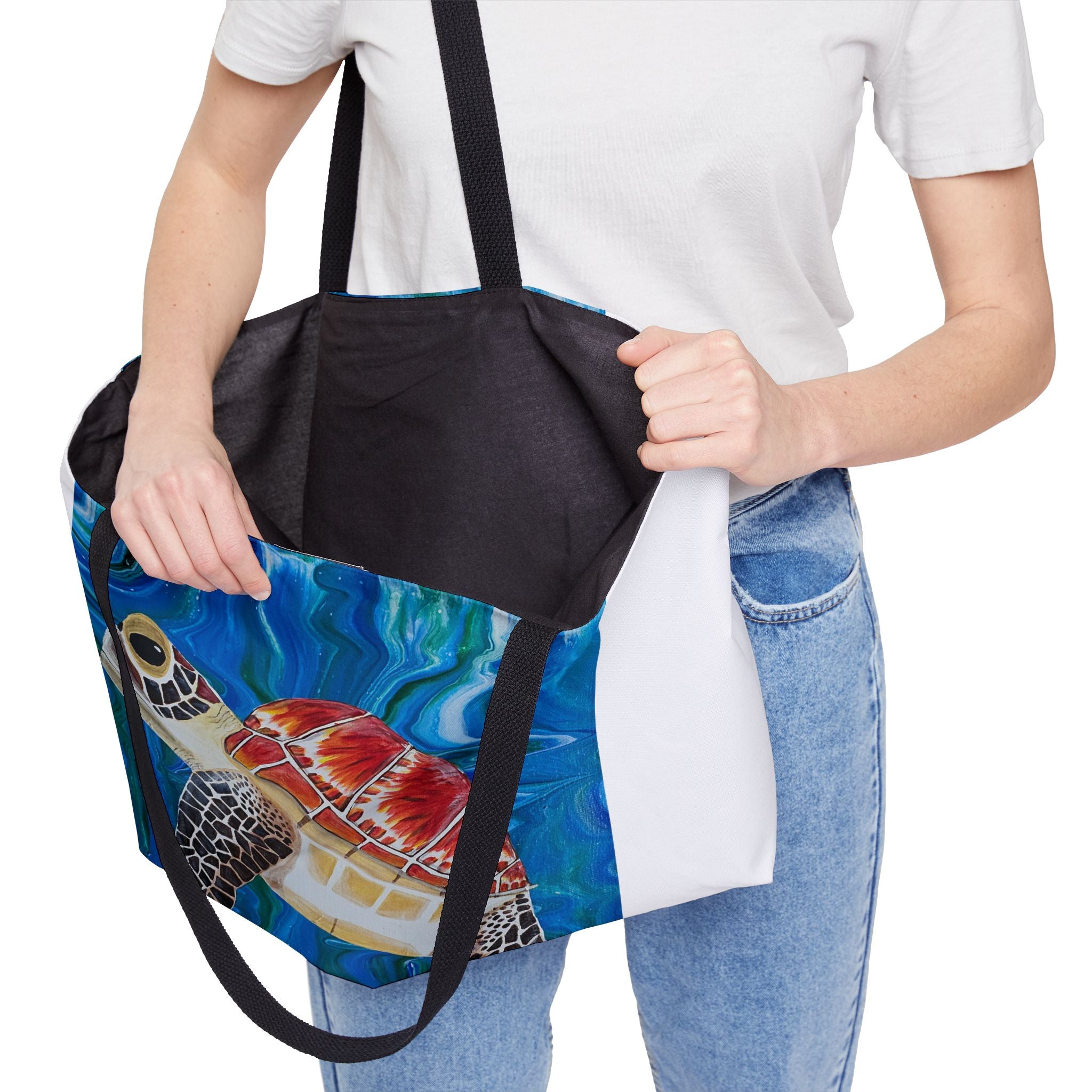 Person holding a tote bag with a turtle design on a white background