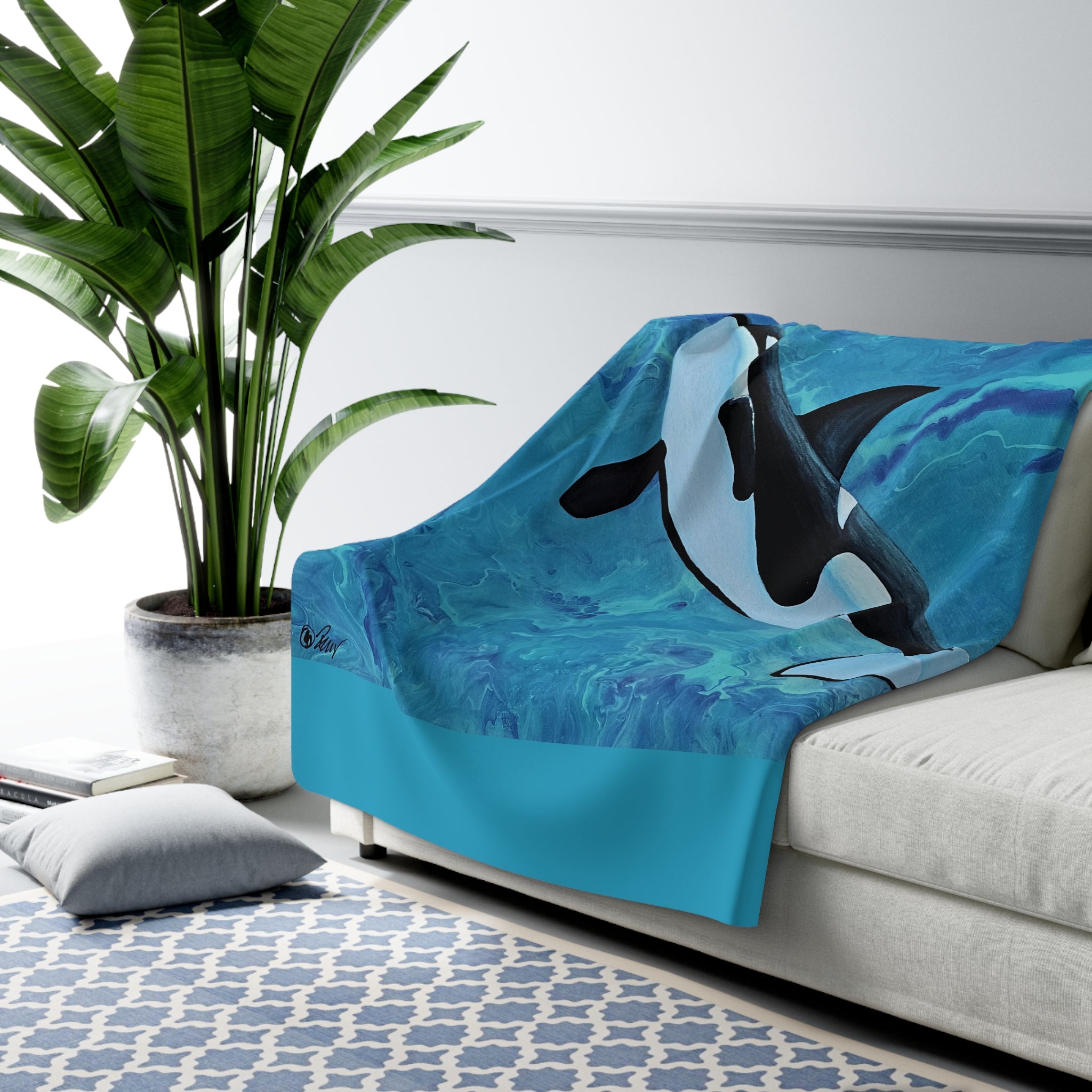 Blue blanket with orca design on a sofa in a living room setting