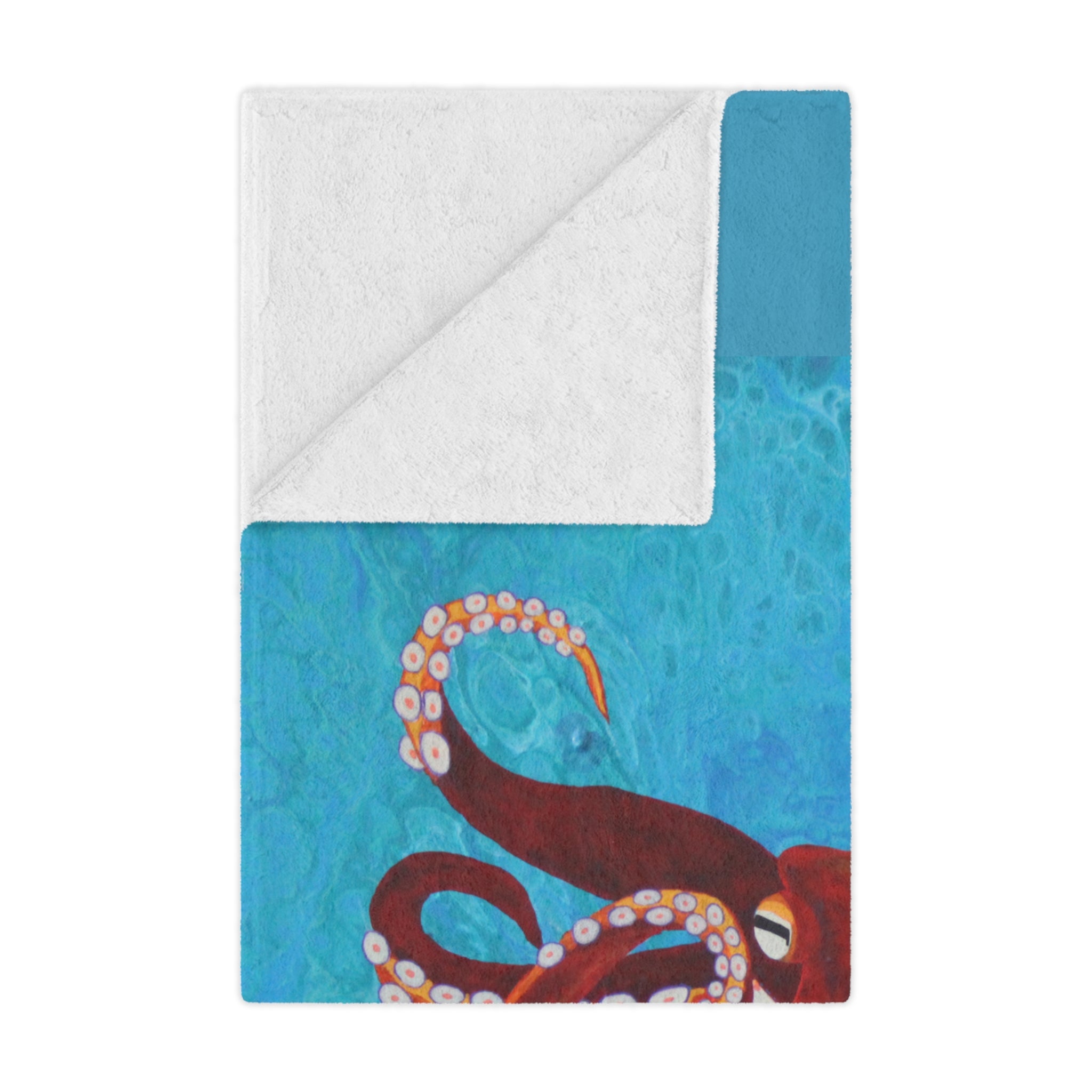 Blanket folded with an octopus design on a blue and white background