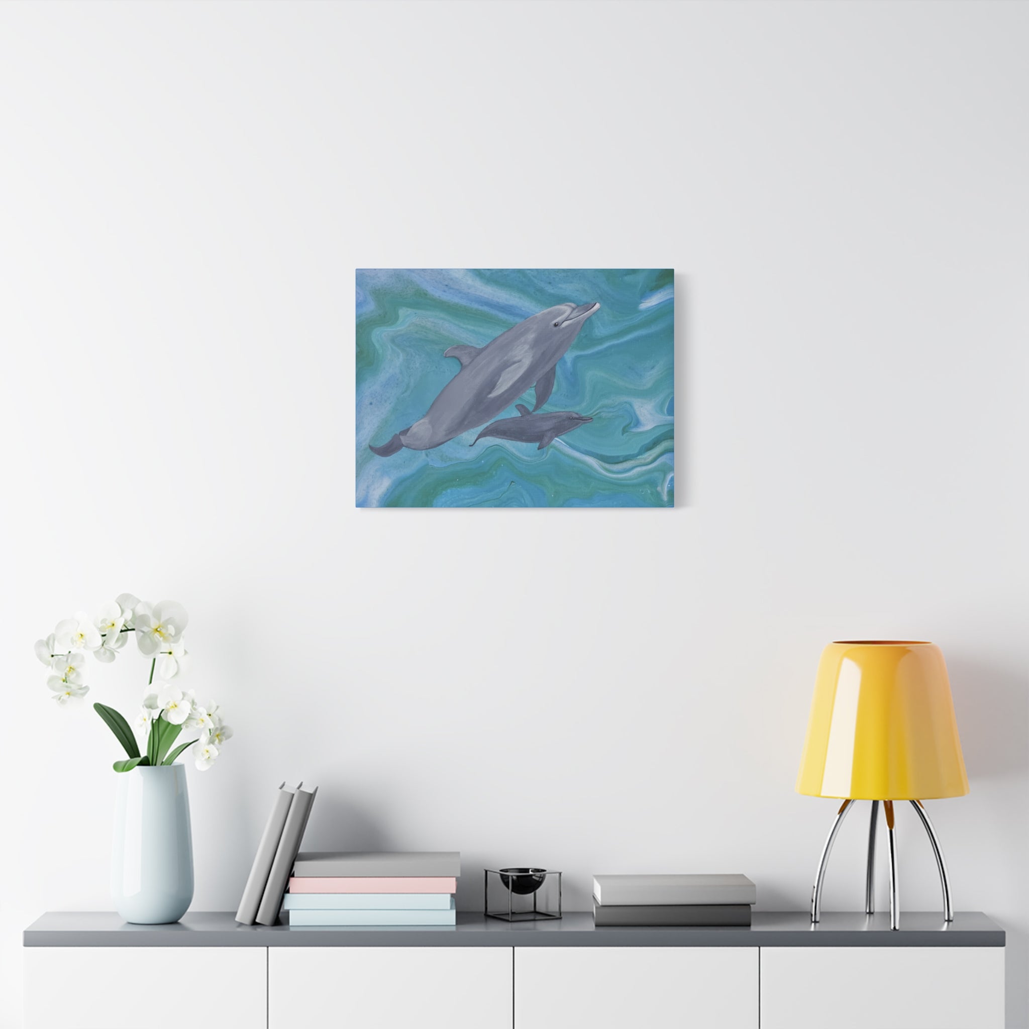 Framed artwork of dolphins on a wall above a shelf with decor items.