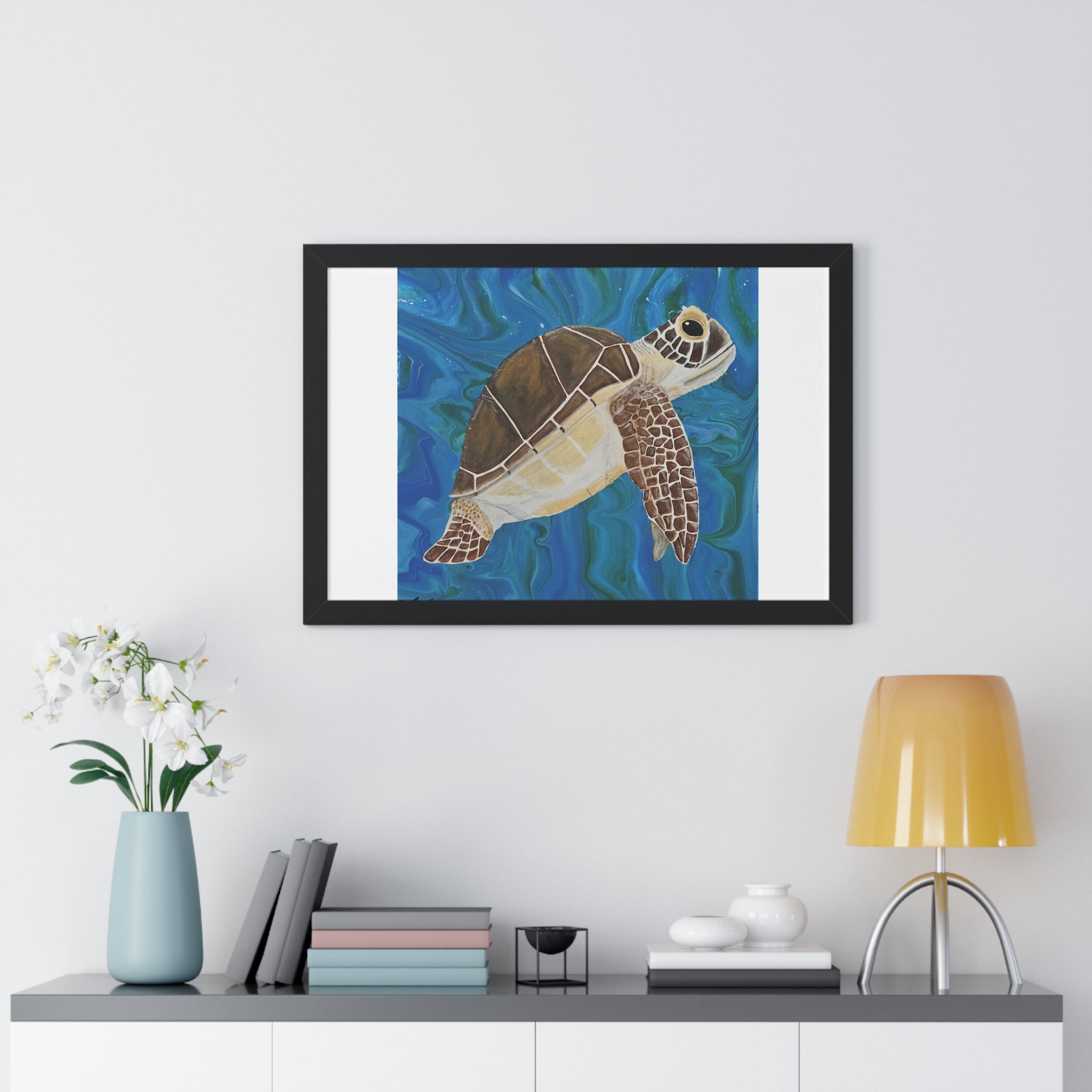 Framed artwork of a turtle on a wall above a shelf with decor items.