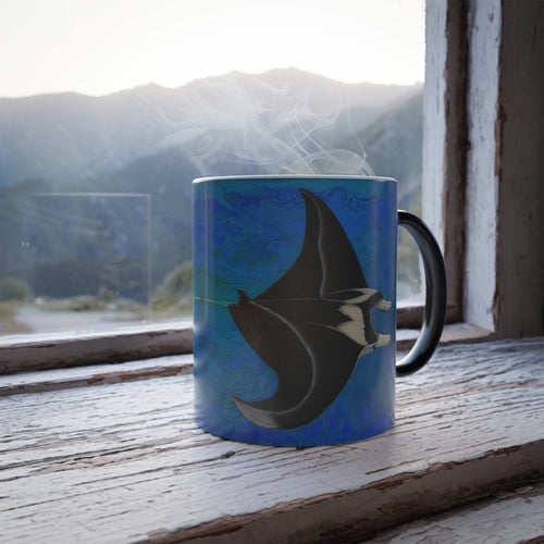 Mug with a manta ray design on a windowsill with a mountain view.