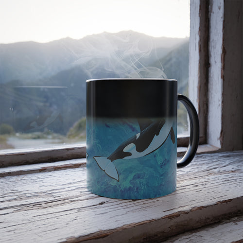 Mug with whale design on a windowsill with a mountain view