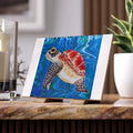 Colorful turtle painting on tile with a stand with candles and a plant in the background