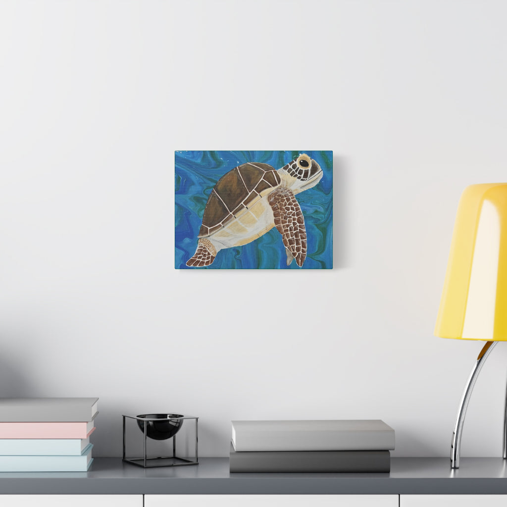 Canvas print of a turtle on a wall above a desk with books and a lamp.