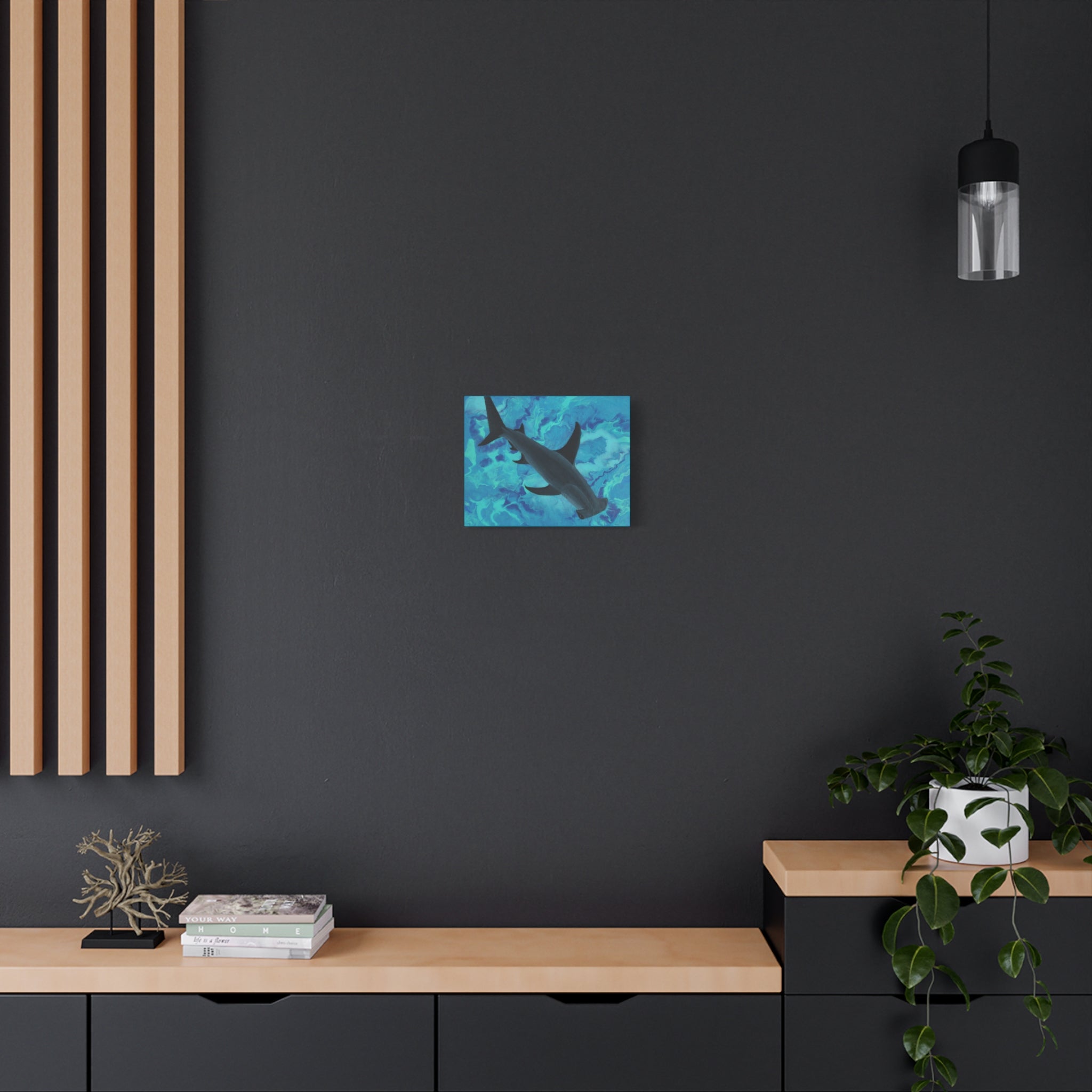 Blue shark canvas print on a dark wall above a wooden shelf.
