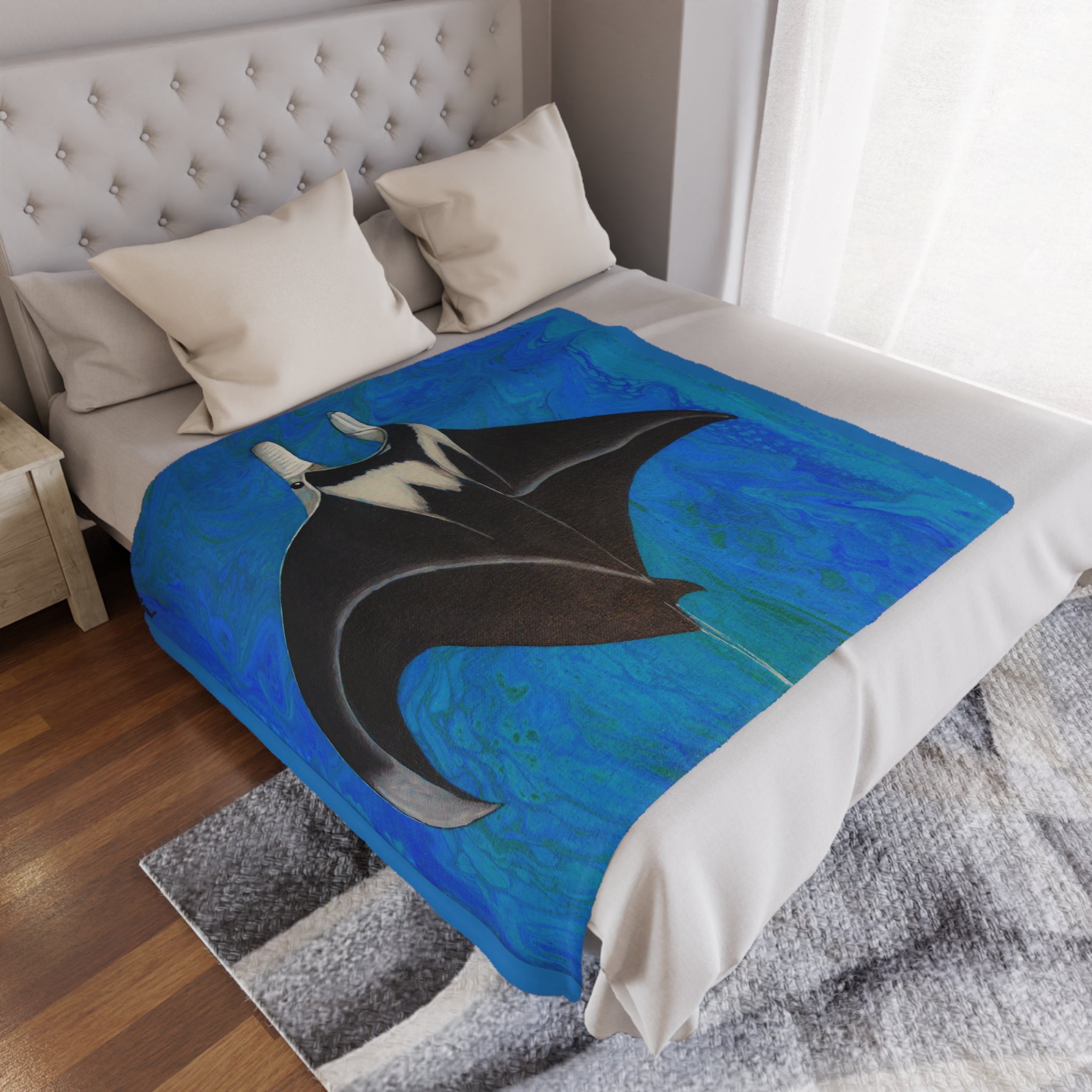 Blue and black abstract design with manta ray blanket on a bed in a bedroom setting