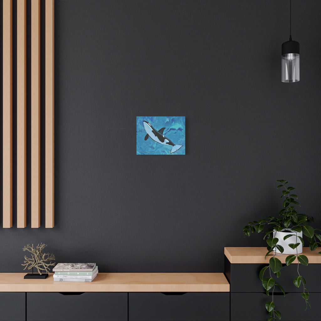 Abstract blue and orca whale canvas print on a dark wall with wooden shelves and decor.