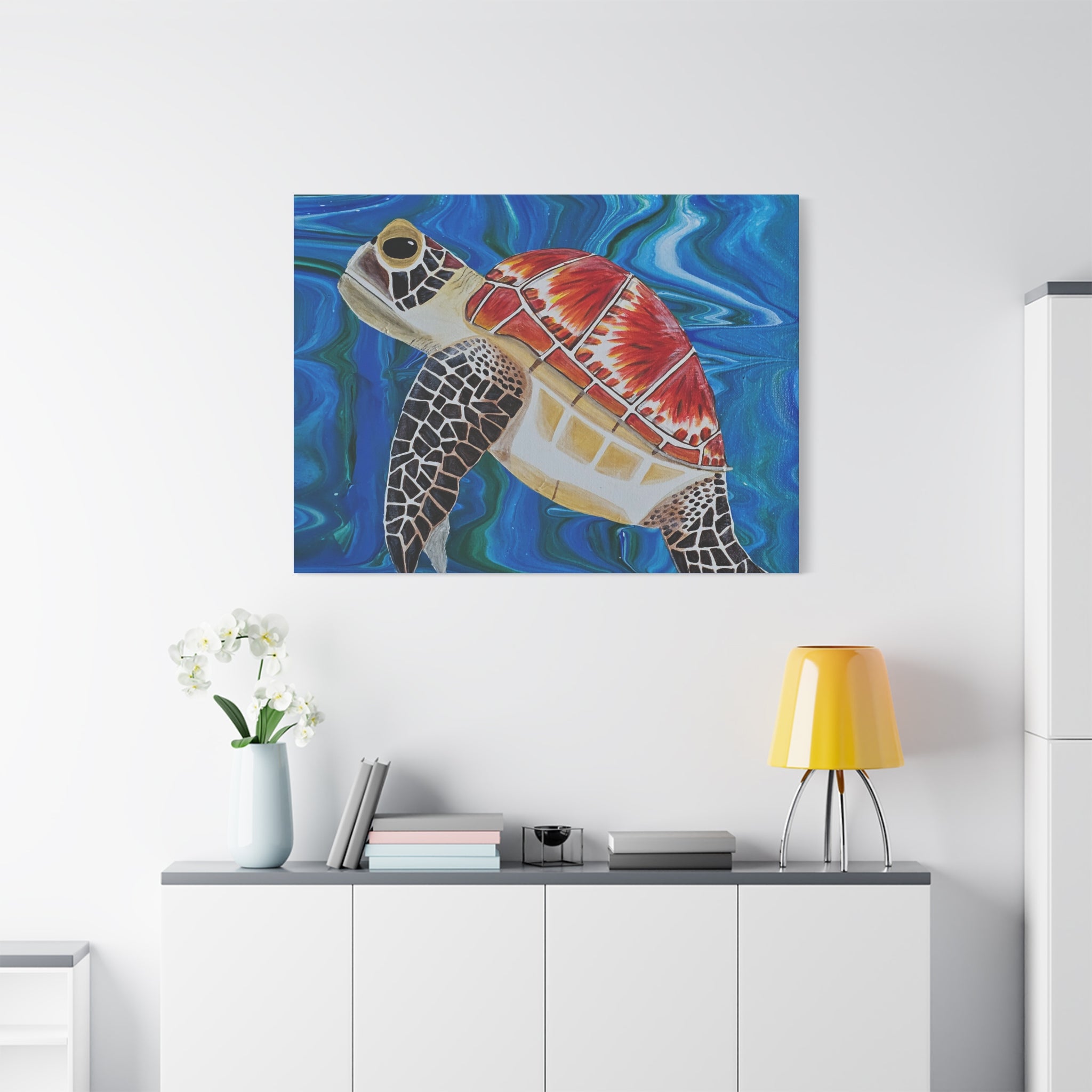 Colorful turtle painting on a white wall above a white cabinet with a yellow lamp.