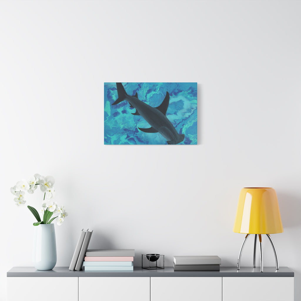 Wall art of a shark in an underwater scene on a white wall above a shelf with decor items.