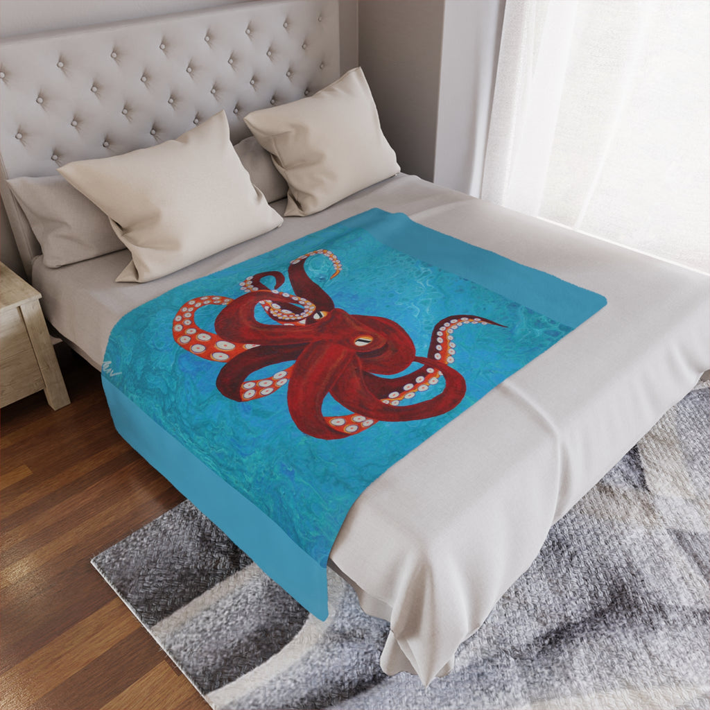 Bed with a red octopus design on a blue blanket in a bedroom setting.