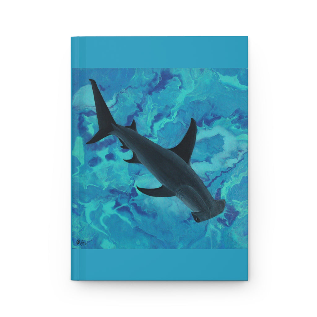 Notebook with a shark illustration on a blue and green abstract patterned cover