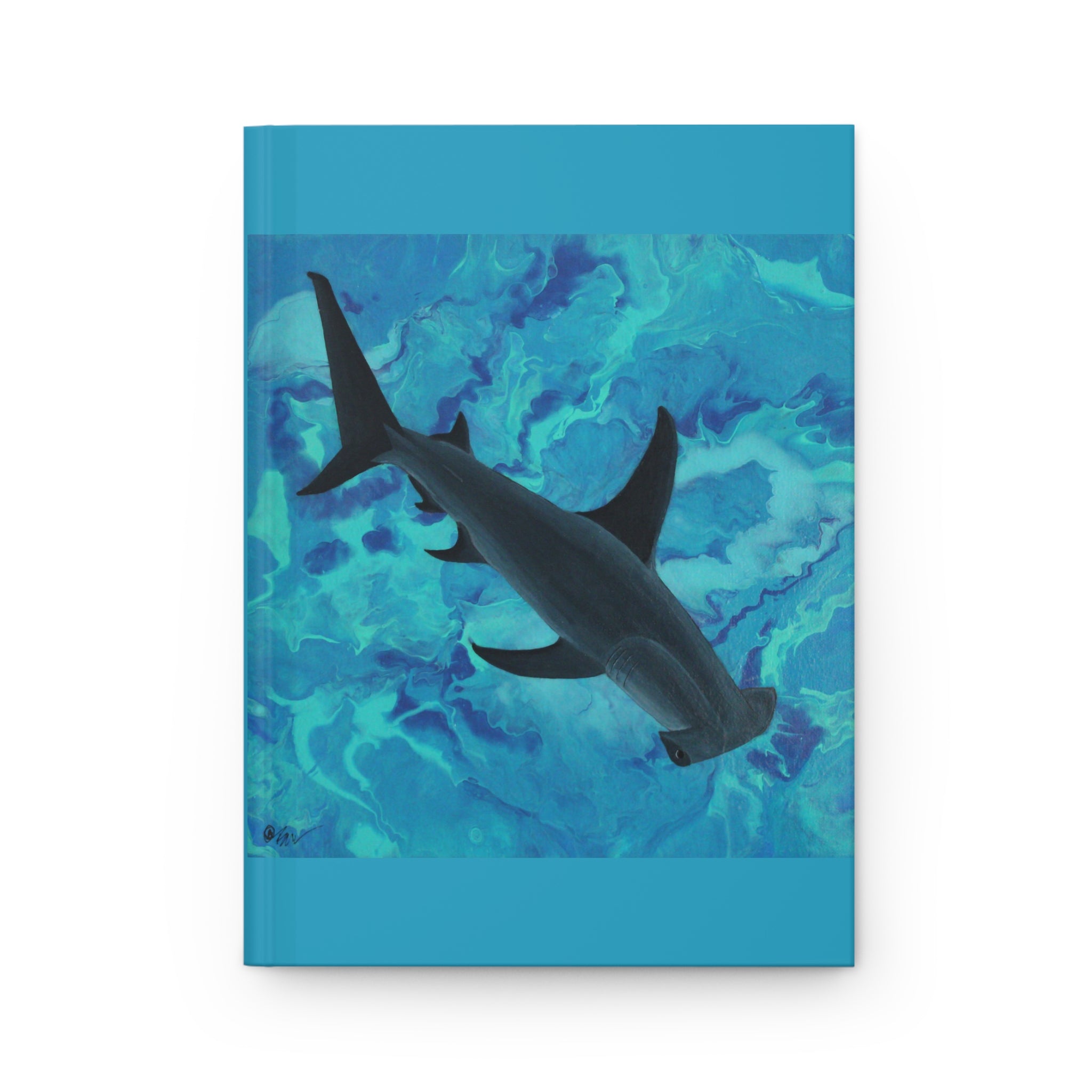 Notebook with a shark illustration on a blue and green abstract patterned cover