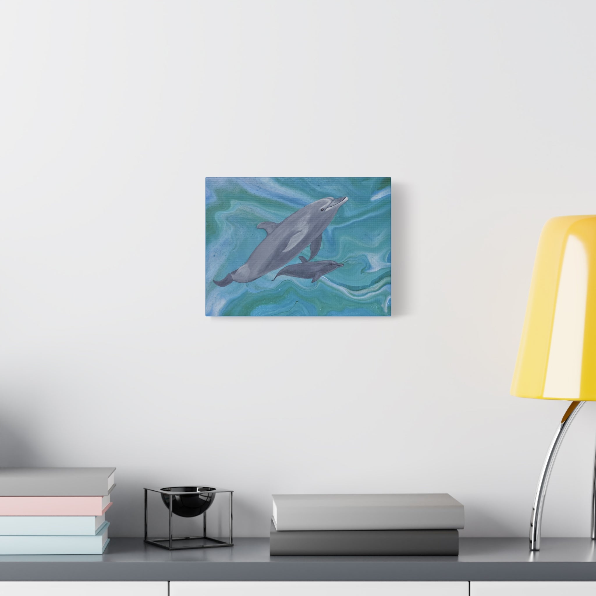 Canvas print of a dolphin in water on a wall above a desk with books and a lamp.