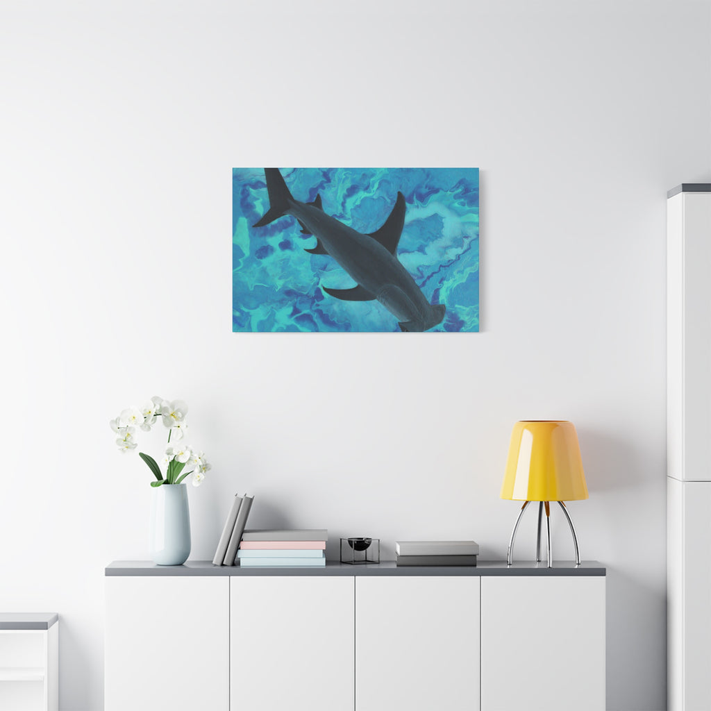 Shark painting on a wall above a white cabinet with a yellow lamp and white flowers.