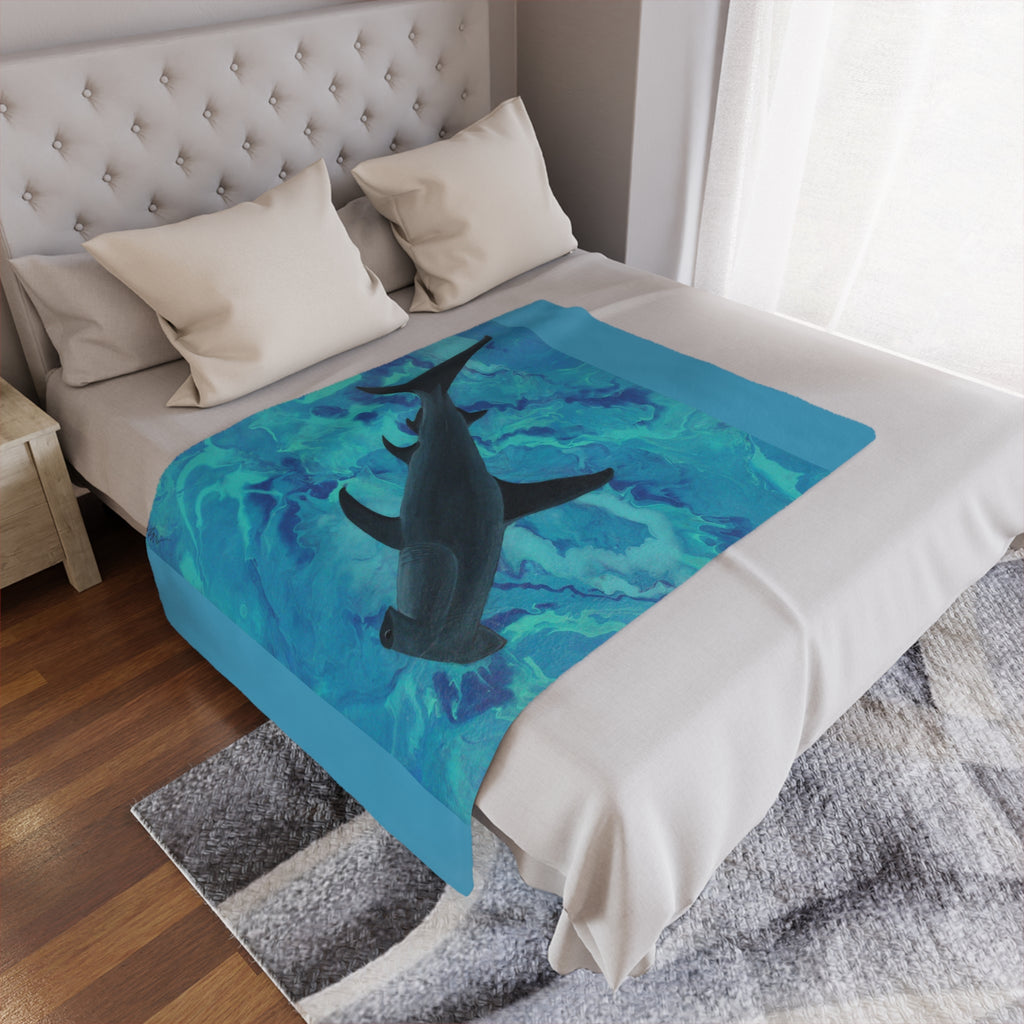Bed with a shark-themed blanket draped over it in a bedroom setting.