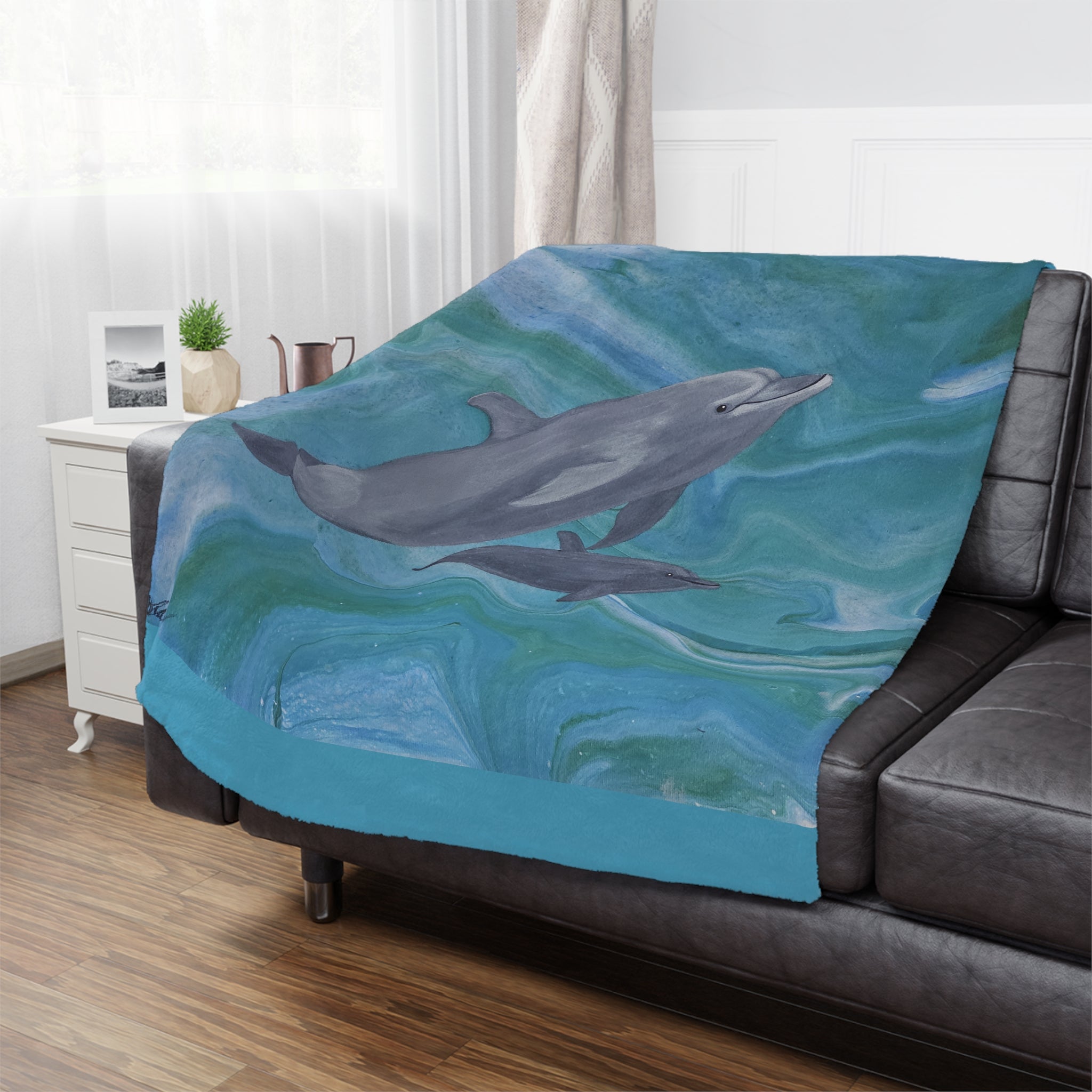 Dolphin-themed blanket draped over a sofa in a living room setting.