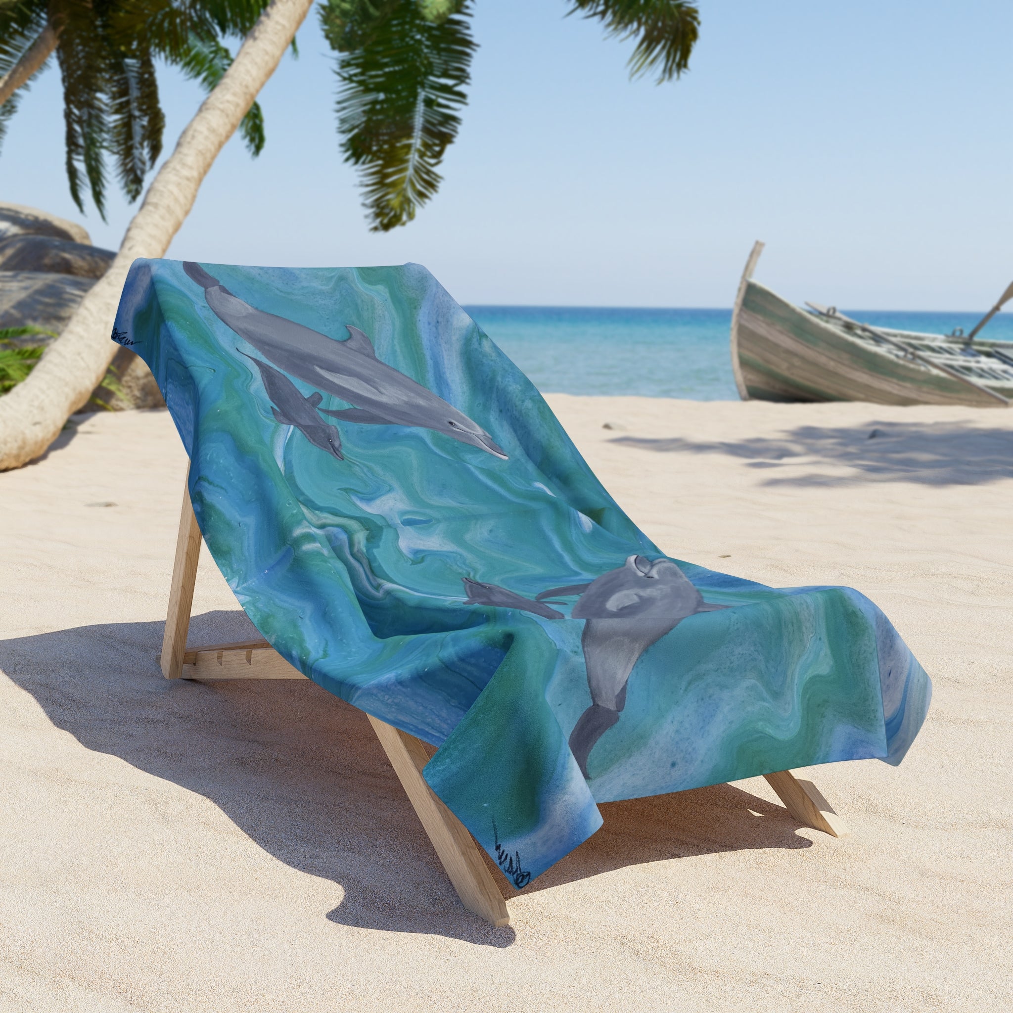 Beach towel/blanket with dolphin design on a wooden chair at a tropical beach.