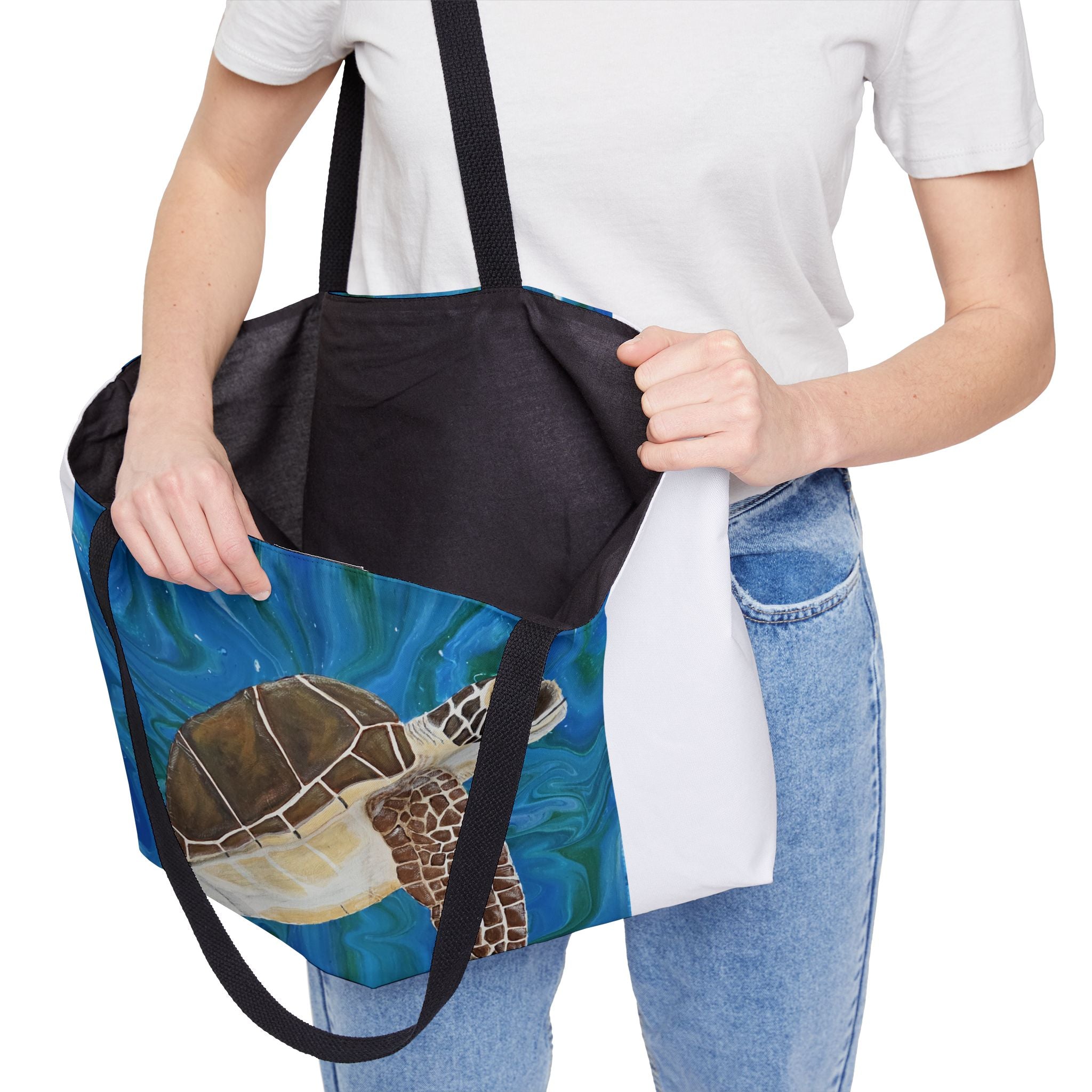 Person holding a tote bag with a turtle design on a white background