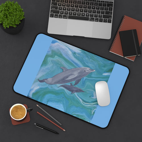 Desk setup with a dolphin-themed desk pad, laptop, and office supplies.