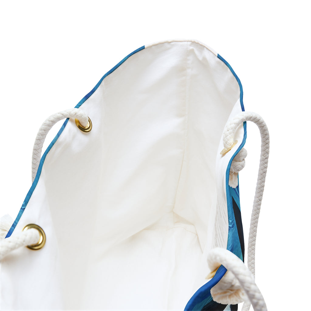 Close-up of a white drawstring bag with blue accents on a white background